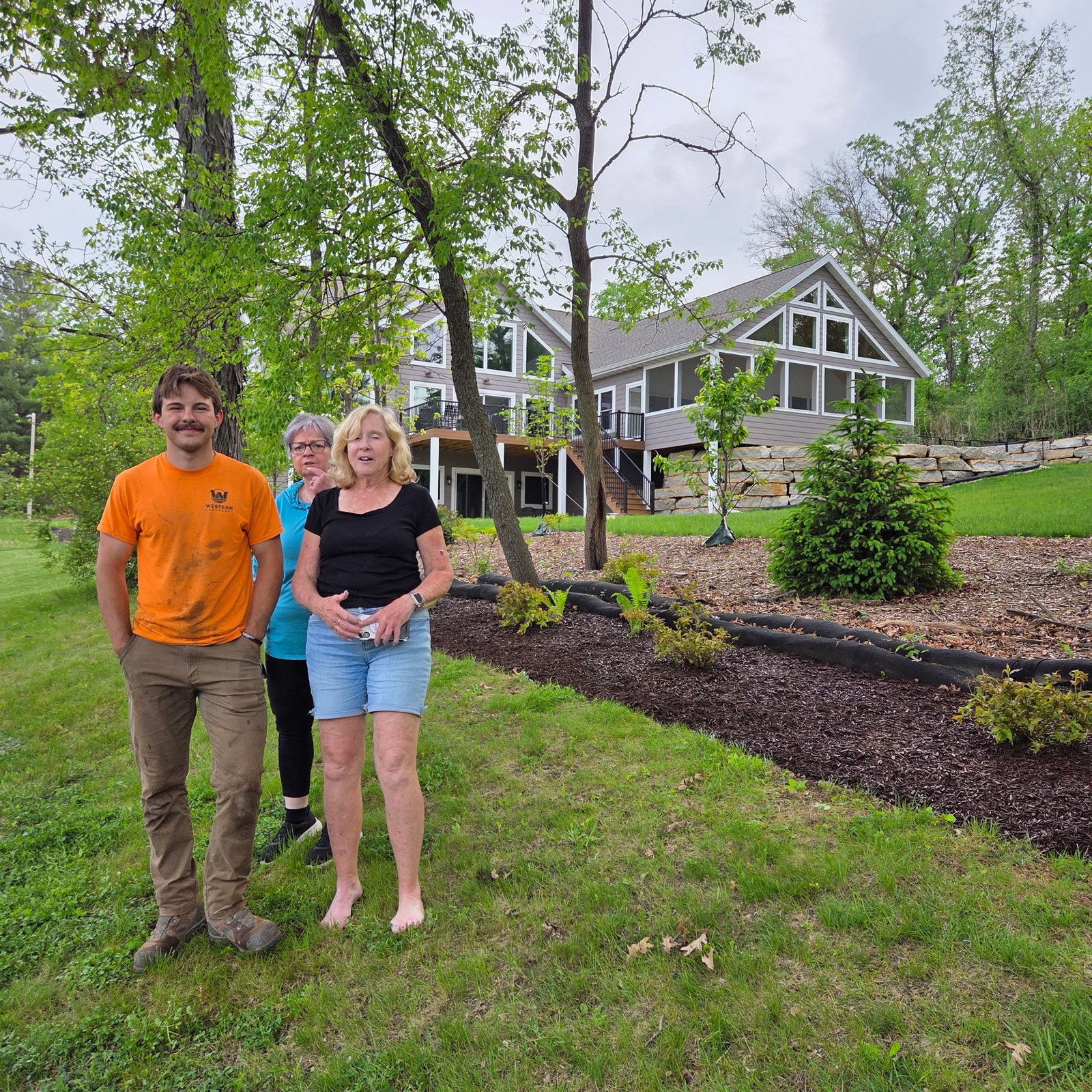 Homeowners with the Western Landscape crew beside fresh landscaping