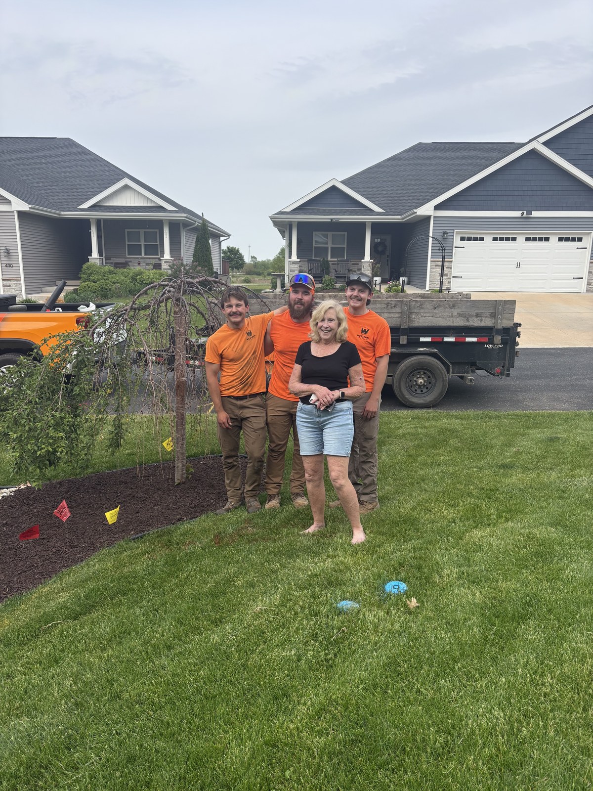Western Landscape crew with a happy customer in front of their home